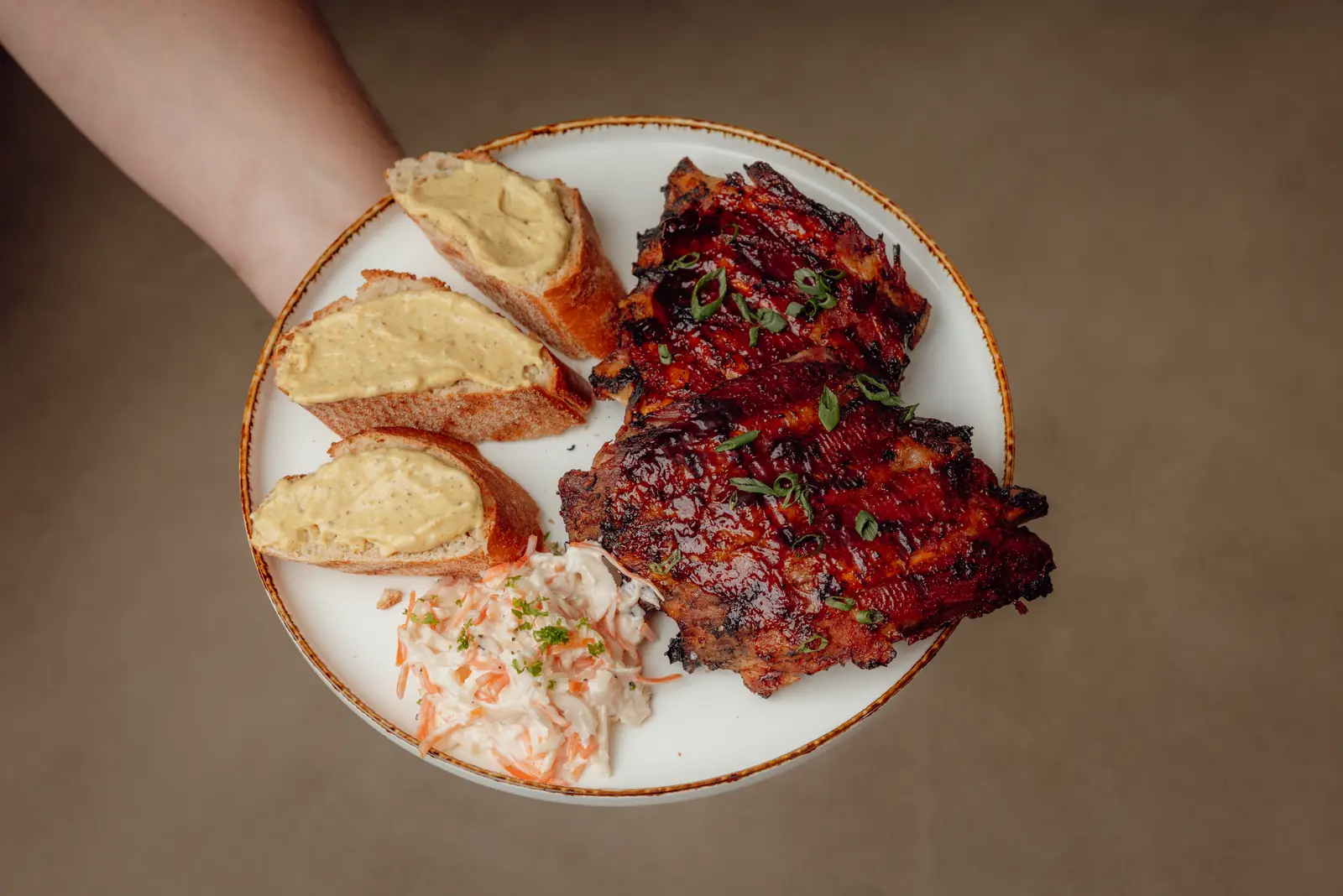 Spareribs met stokbrood en coleslaw op een bord