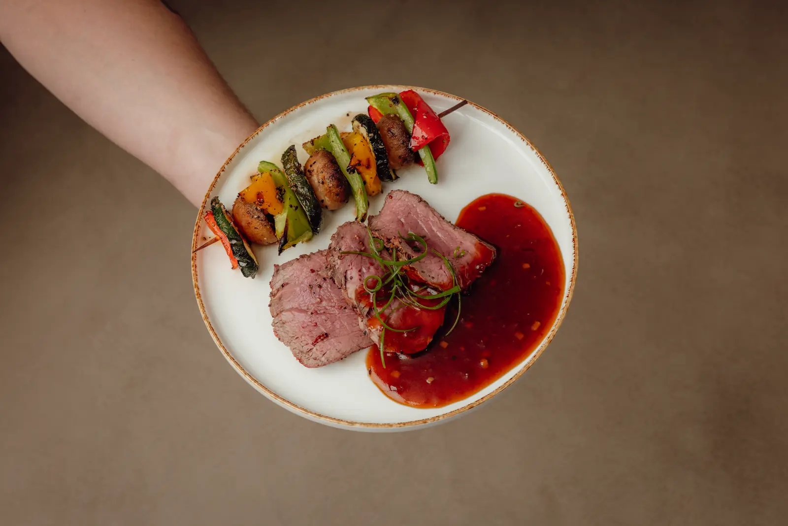 Ossenhaas in plakjes met saus en een groentespies