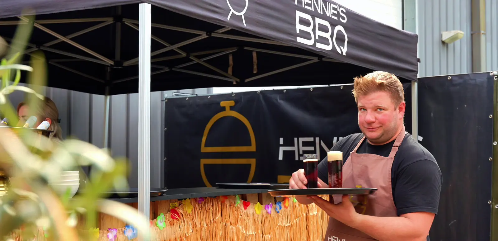 Hendrik met een dienblad vol drankjes achter de bar