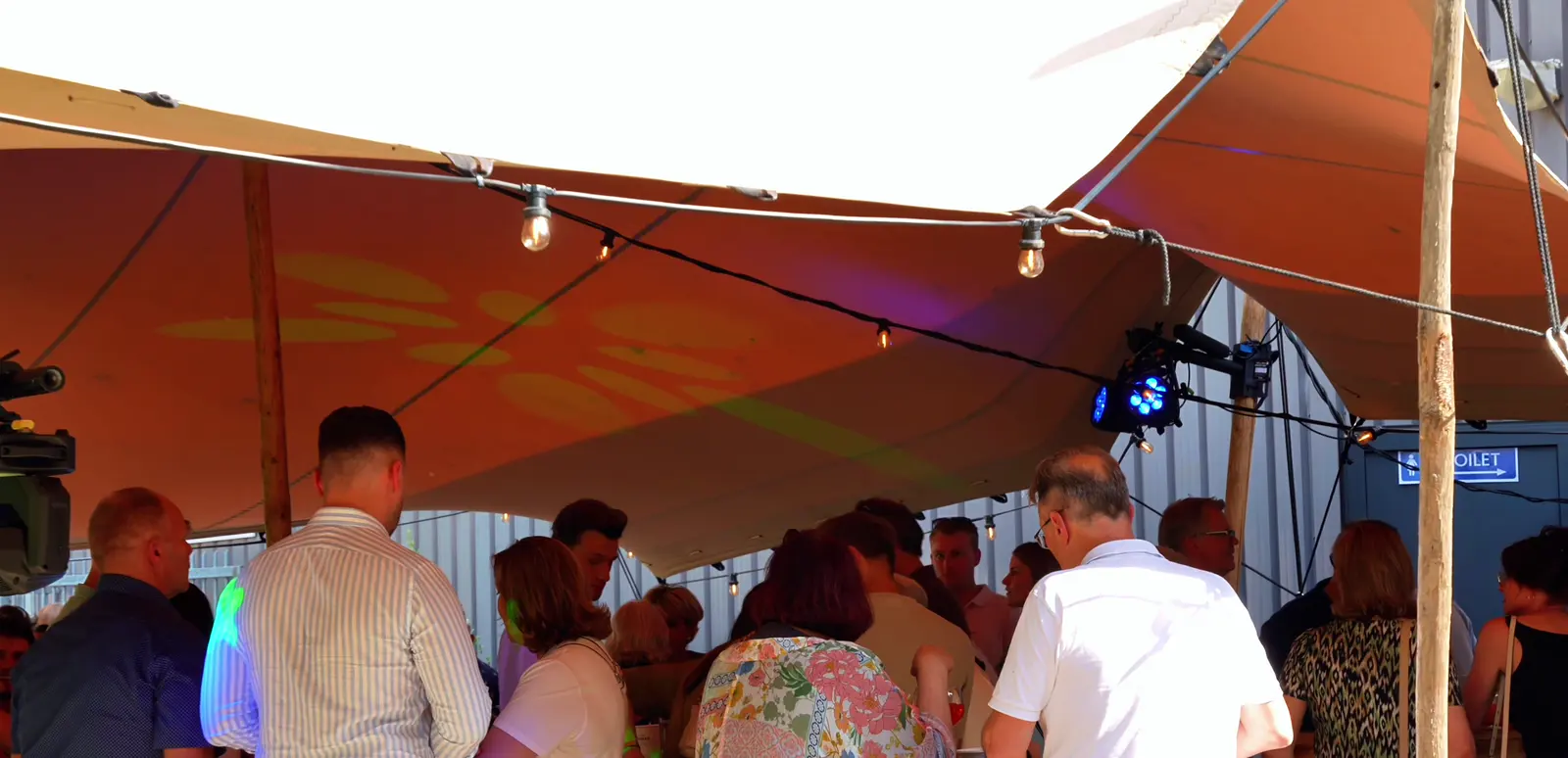 Gasten onder de overkapping van Hennie's BBQ bij een evenement